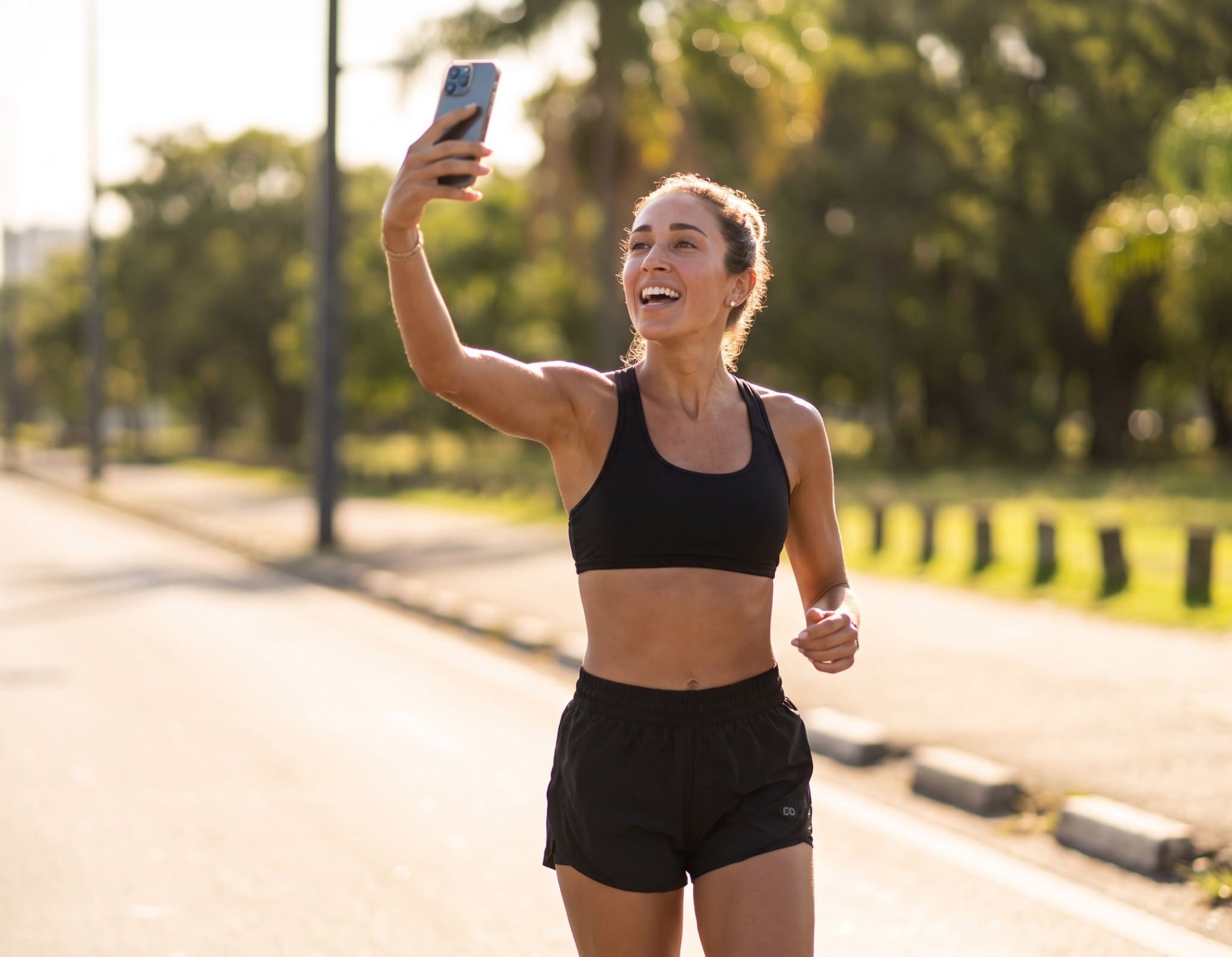 Mulher praticando esporte enquanto grava conteúdo com o celular